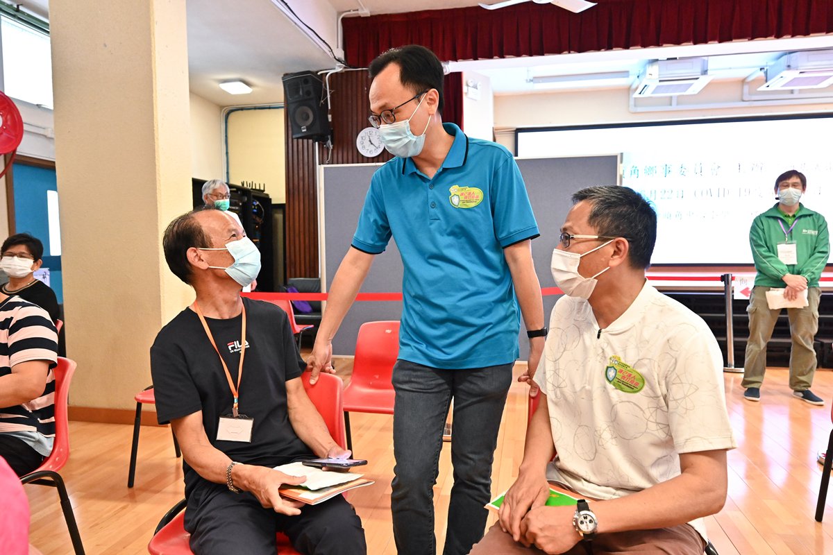 左鄰右里:  聶德權（中）到沙頭角墟視察街坊接種新冠疫苗情況，其間與沙頭角區鄉事委員會主席李冠洪（右）和區內街坊交談。