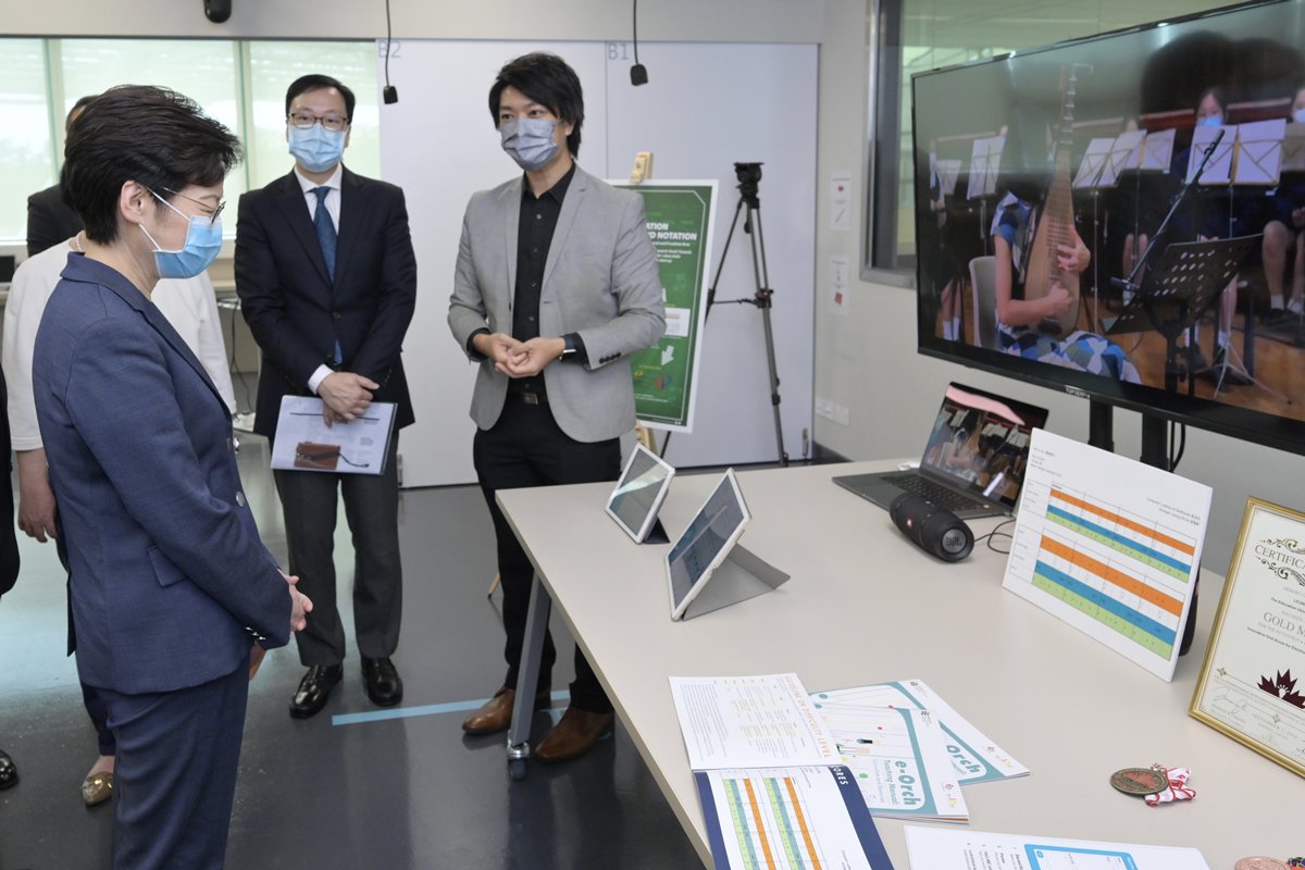 嶄新教材:  教大代表向林鄭月娥（左）介紹方格樂譜。樂譜由教大研發，容易閱讀，能引起學生學習音樂的興趣。
