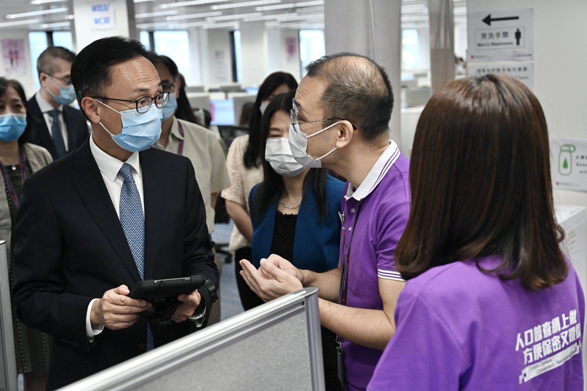 打氣:  聶德權（左）到訪政府統計處，與人口普查服務中心的統計員交談，了解其工作情況。
