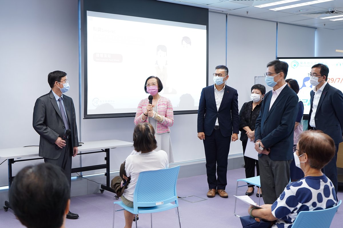 預防感染:  陳肇始（後排左二）感謝長者參與葵青地區康健中心提供的外展疫苗接種服務。