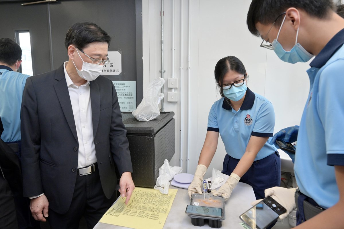 妥善安排:  李家超（左）了解竹篙灣檢疫中心的膳食安排。