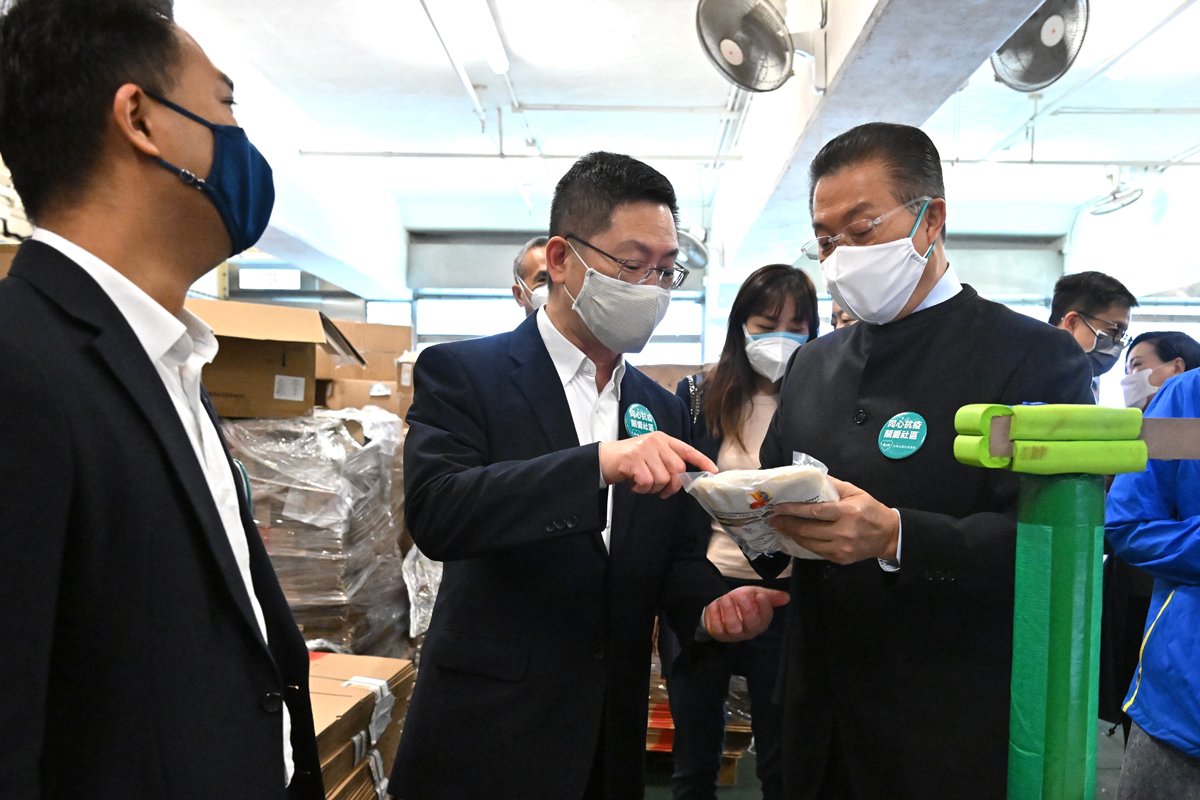 社區抗疫:  薛永恒（左二）探訪全港社區抗疫連線位於九龍灣青少年軍的義工總部，了解派送物資流程。
