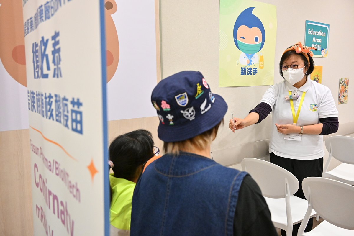 用心解說:  護士在教育區以生動有趣的方式講解兒童接種新冠疫苗注意事項，希望減輕兒童的壓力。
