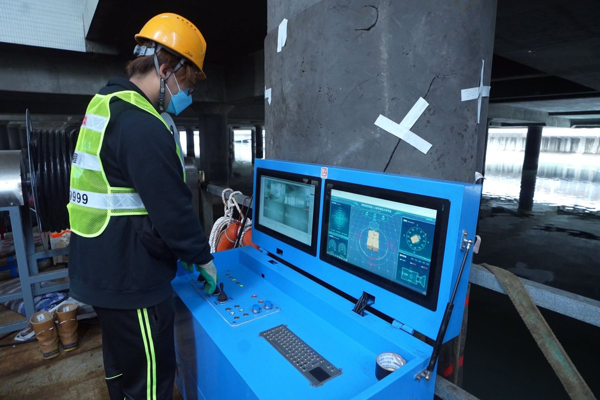 遙距操控:  工作人員遙距操控機械人「深水清」進入河道，利用安裝在機械人的閉路電視和聲納裝置尋找並吸取淤泥。