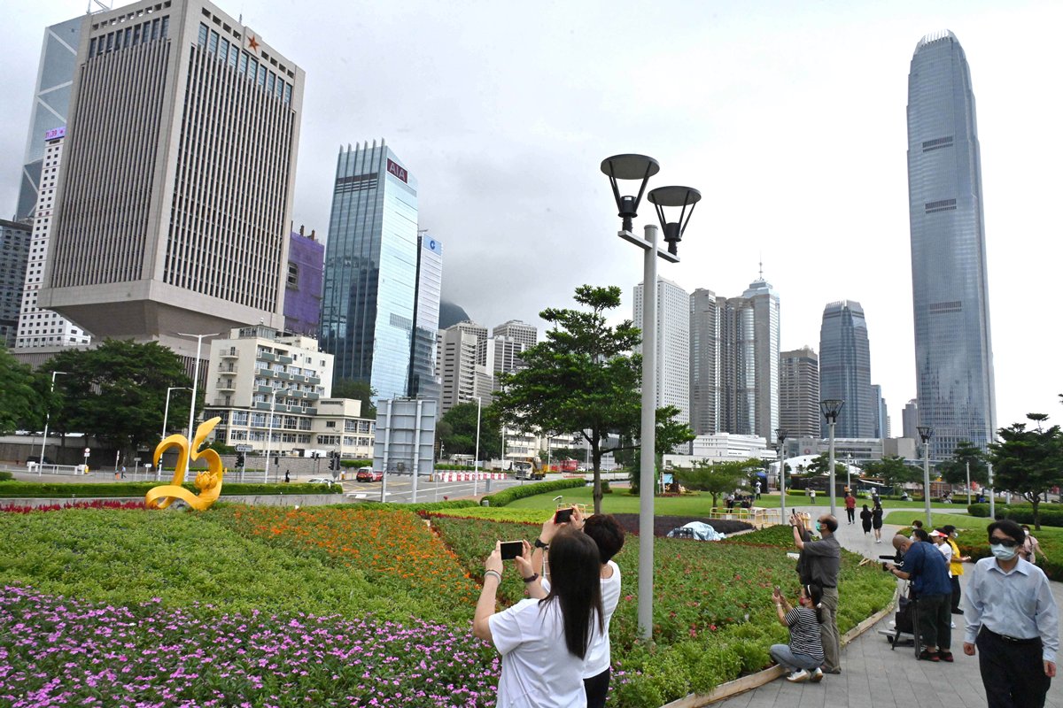 珍惜美景:  上班一族途經花海，紛紛駐足欣賞，拍照留念。