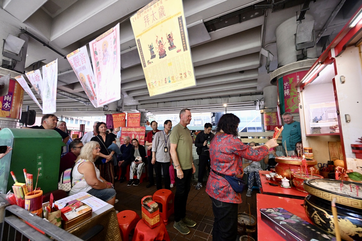 橋底文化:  一群旅客正體驗香港獨特的打小人文化。