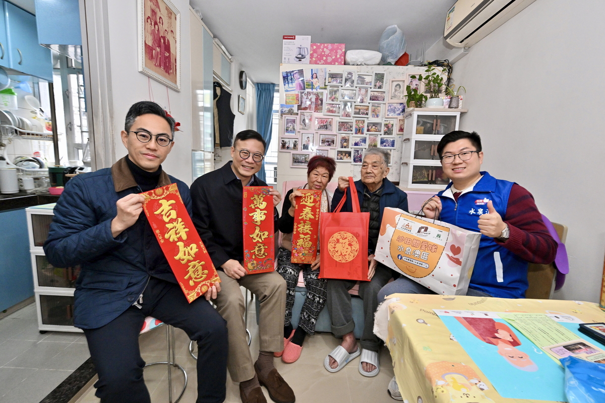 送上祝福:  張國鈞（左二）探訪居於沙田水泉澳邨的基層家庭。