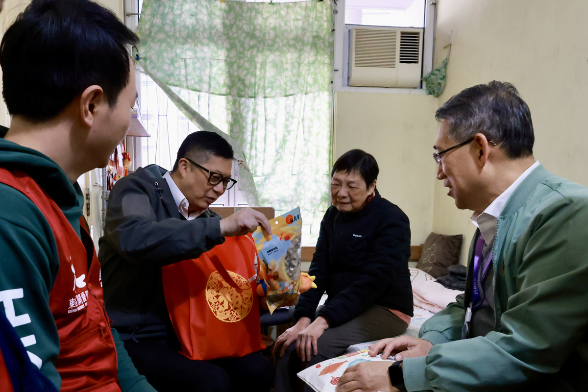 節日祝福:  鄧炳強（左二）向康東邨長者戶送上賀年福袋。