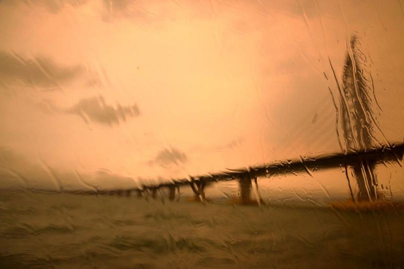 【晴天拍雨天也拍】
勤勞的攝影師，雨天也應該出動！這張作品利用玻璃上的雨水，模糊遠方大橋的影像，營造詩意的效果，是雨天經常用到的攝影技巧。
郭建設／攝...