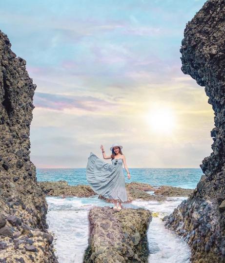 站在鬼斧神工的海蝕石頭旁，湛藍海水與陽光交織的唯美景色...
