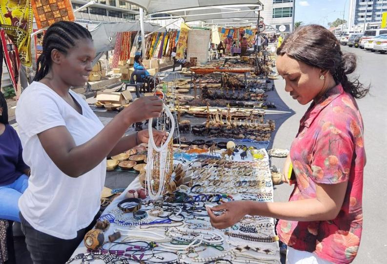 The display of colorful artistic items adorned the floor and stalls at a bustling informal market in...