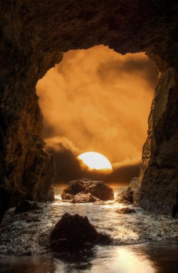 在海蝕洞的秘境中，看見日落在洞口慢慢落下...