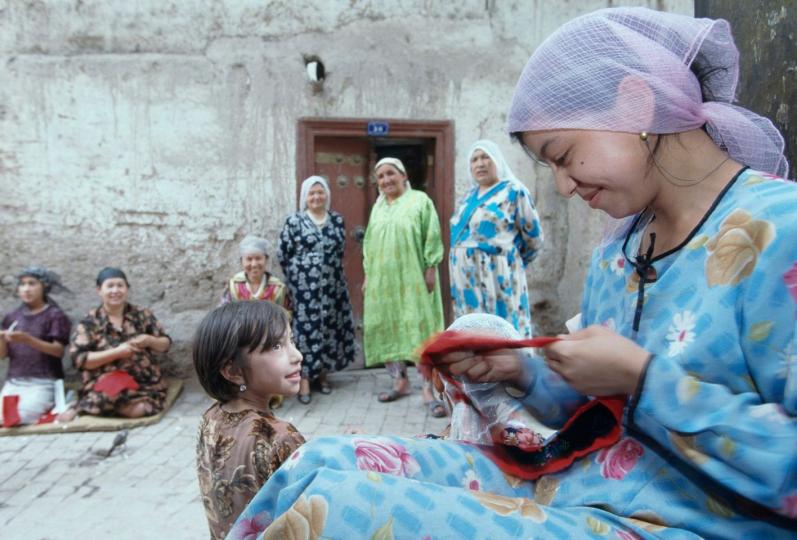 【新疆女紅】
新疆喀什的街巷，一位維吾爾族婦女正在做女紅，美麗的構圖美麗的人。
謝光輝／圖...