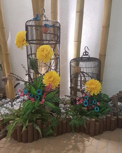 美麗的雀籠
這兩個大小不一的雀籠用了黃花、紅、藍色花和綠葉美化，相當搶眼。...