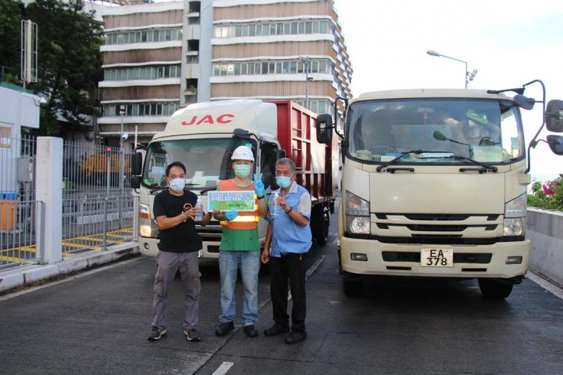  環境保護署人員在廢物轉運站向廢物運輸車輛司機派送消毒搓手液
