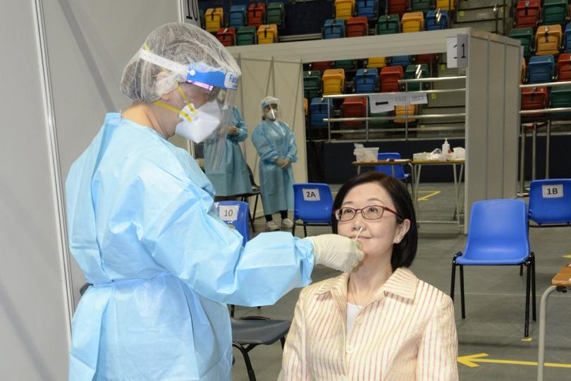 踴躍參與: 陳漢儀(右)視察設於灣仔伊利沙伯體育館的社區檢測中心,並即場接受採樣。 踴躍參與: 陳漢儀(右)視察設於灣仔伊利沙伯體育館的社區檢測中心,並即場接受採樣。