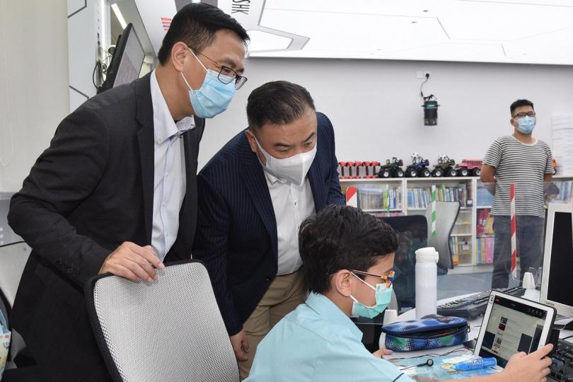 探訪學校:  楊潤雄（左）到香港潮商學校的電腦室，旁觀學生參與網上課堂的情況。