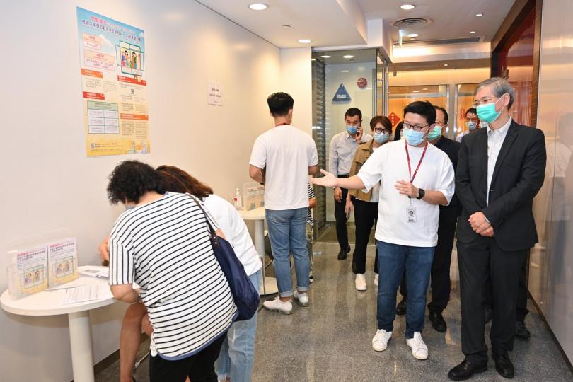 申請首日:  羅致光（右一）與銀行職員交談，了解他們接受低收入家庭新來港定居成員申請一次過津貼的情況。