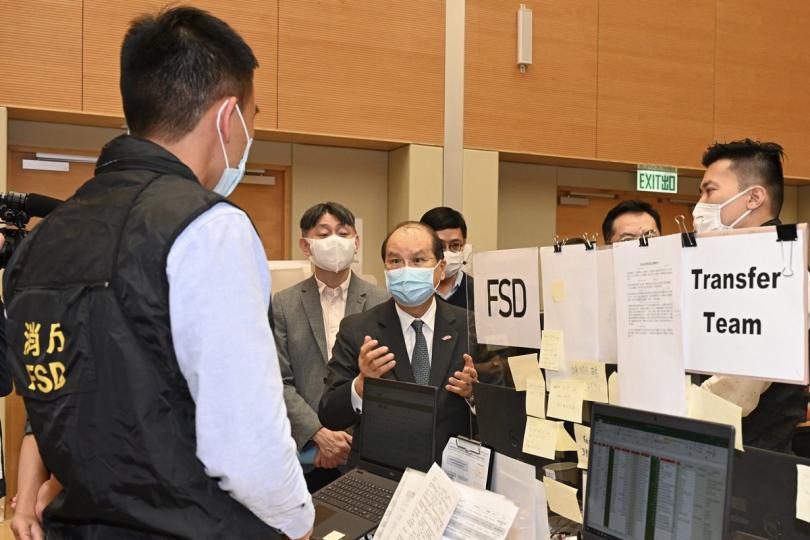 強力支援:  張建宗（中）視察個案追蹤辦公室，與辦公室的消防處人員交談。   