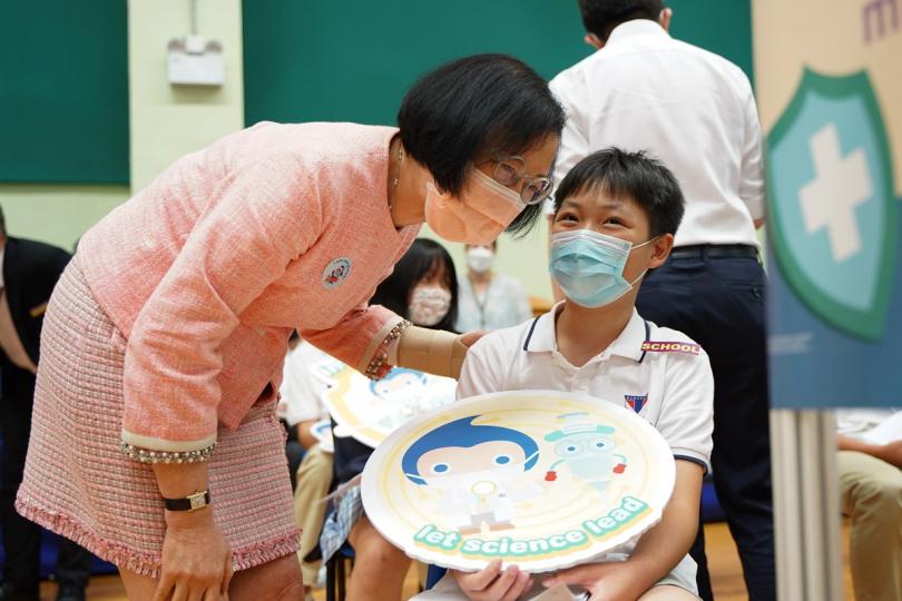 問候:  陳肇始（左）在香港大學鴨脷洲體育館社區疫苗接種中心視察滬江維多利亞學校師生接種2019冠狀病毒病疫苗，並與已接種疫苗的學生交談。