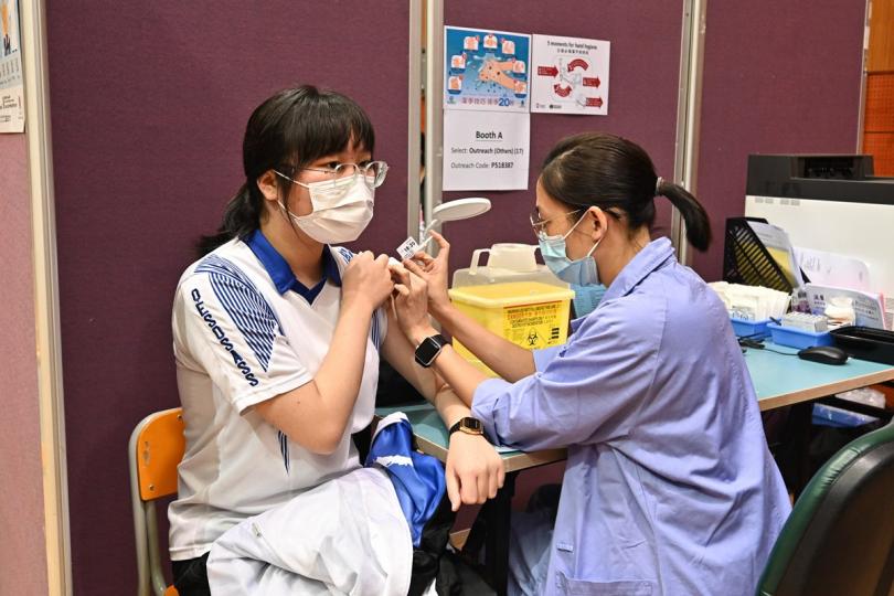 保障自己:  一名學生通過政府外展服務在伊利沙伯中學舊生會中學接種新冠疫苗。