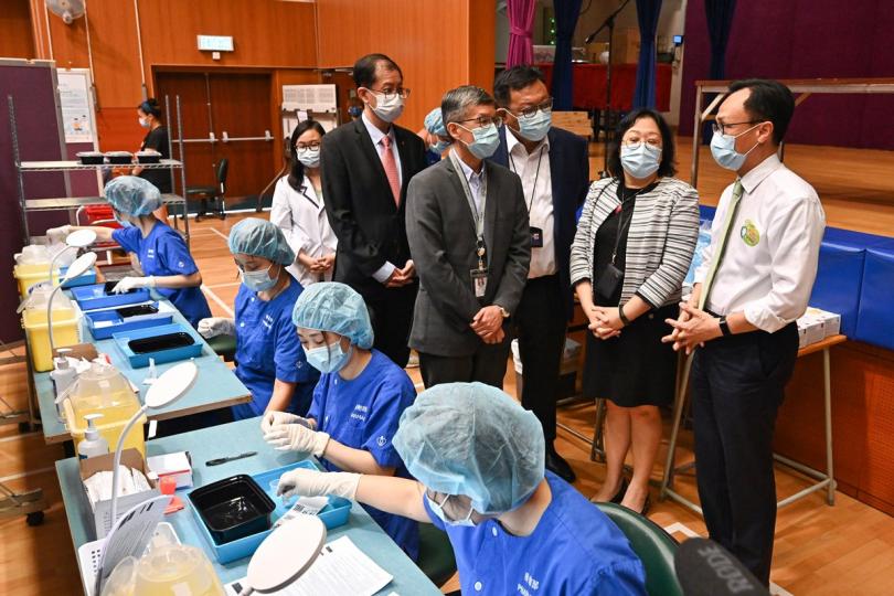 積極參與: 政府外展到校接種新冠疫苗服務展開,聶德權(右)到伊利沙伯中學舊生會中學視察接種情況和安排。 積極參與: 政府外展到校接種新冠疫苗服務展開,聶德權(右)到伊利沙伯中學舊生會中學視察接種情況和安排。