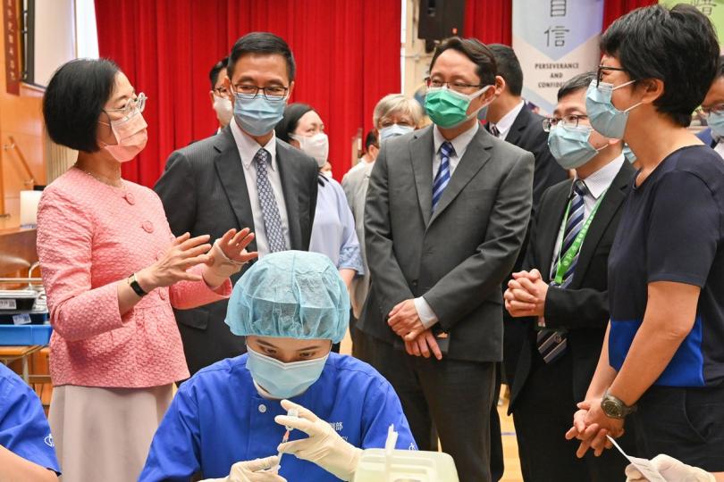 預防感染:  政府外展到校接種新冠疫苗服務展開，陳肇始（後排左一）、楊潤雄（後排左二）到香港道教聯合會青松中學視察接種情況。
