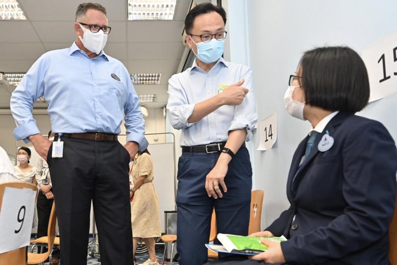 一呼百應: 聶德權(中)視察香港迪士尼樂園員工接種新冠疫苗的情況,其間與完成接種的餐飲部員工交談。 一呼百應: 聶德權(中)視察香港迪士尼樂園員工接種新冠疫苗的情況,其間與完成接種的餐飲部員工交談。