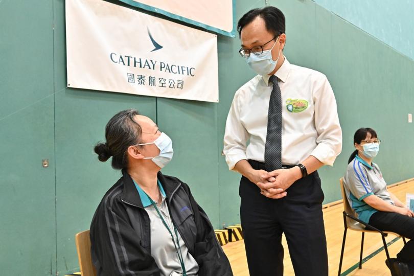 全民起動:  聶德權（中）與已接種疫苗的國泰職員交談。   
