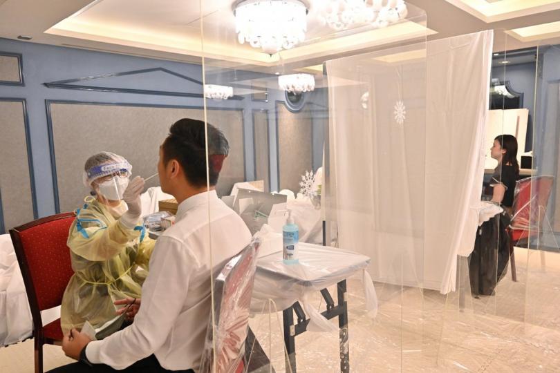 有序檢測: 工作人員為尖沙咀指明受限區域內的受檢人士以咽喉和鼻腔合併拭子採樣。 有序檢測: 工作人員為尖沙咀指明受限區域內的受檢人士以咽喉和鼻腔合併拭子採樣。