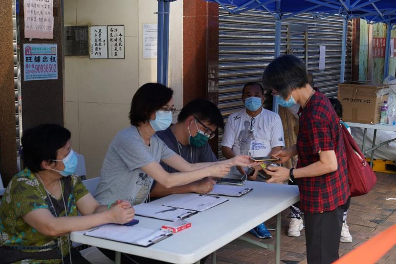 執法行動: 工作人員在上環海景大廈檢查受限人士是否已接受強制檢測。 執法行動: 工作人員在上環海景大廈檢查受限人士是否已接受強制檢測。