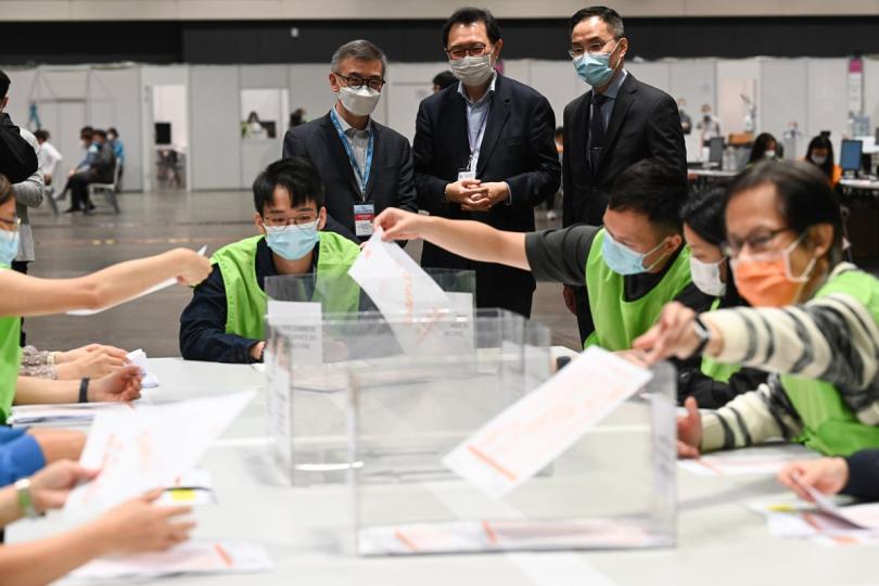 從旁觀察:  馮驊（後排中）到設於會議展覽中心的中央點票站，視察工作人員為2021年立法會選舉點票進行的模擬情景演練。