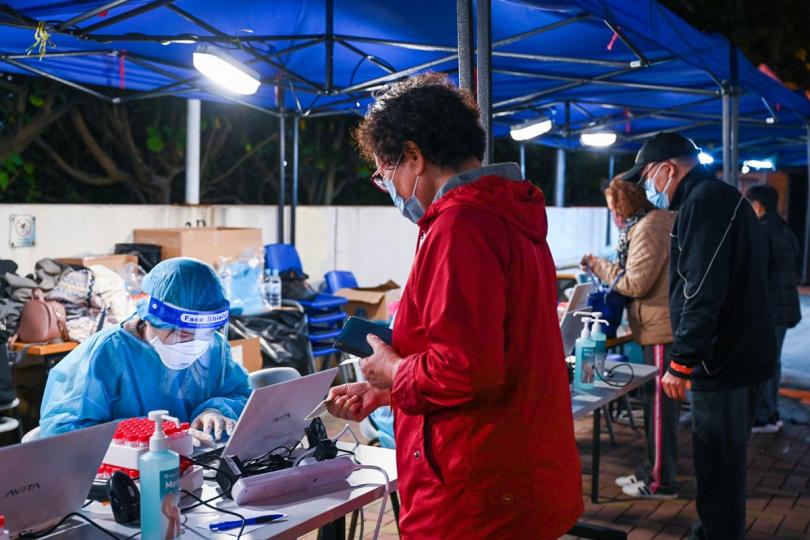 遵從安排:  工作人員在葵涌邨曉葵樓受限區域為受檢人士登記檢測。