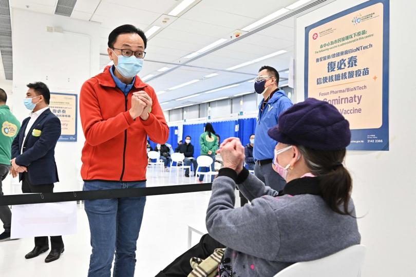 視察運作: 聶德權(左)到教育局九龍塘教育服務中心社區疫苗接種中心視察,其間與剛接種疫苗的市民交談。 視察運作: 聶德權(左)到教育局九龍塘教育服務中心社區疫苗接種中心視察,其間與剛接種疫苗的市民交談。
