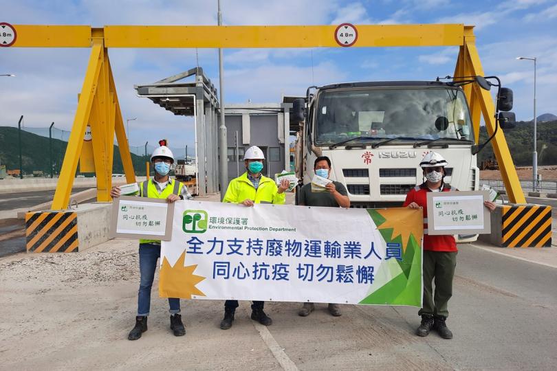齊心抗疫: 環保署人員在新界東南堆填區向建築廢物收集車司機派發快速抗原測試套裝。 齊心抗疫: 環保署人員在新界東南堆填區向建築廢物收集車司機派發快速抗原測試套裝。