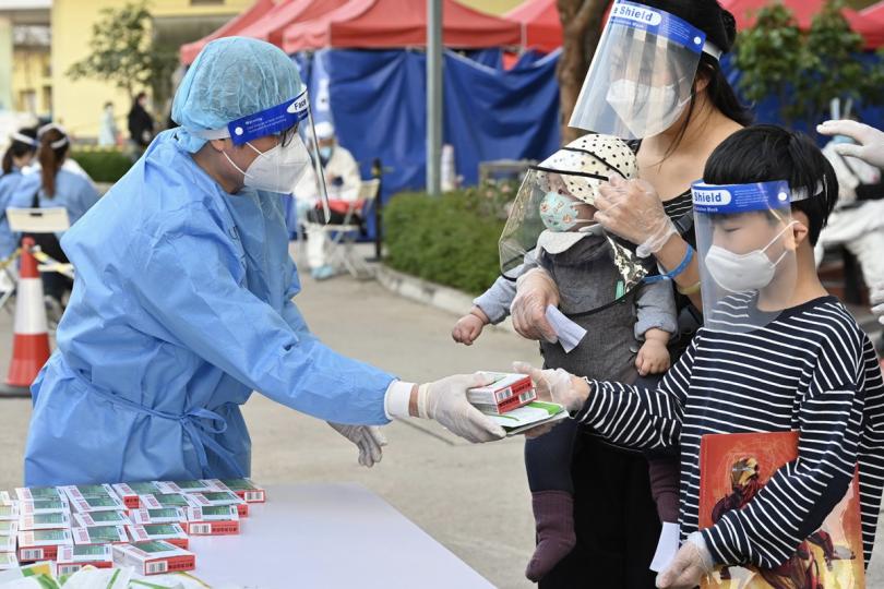 中央支援:  工貿署人員向居民派發中央政府捐贈的抗疫物資，包括中成藥。