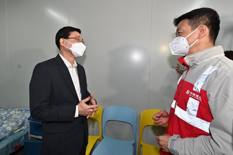 準備就緒:  李家超（左）聽取承建商人員介紹新田社區隔離設施內的新建單位。