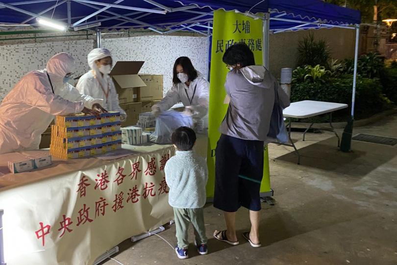 同心抗疫:  工作人員向榮福中心第1座的受檢居民派發由中央人民政府捐贈的抗疫中成藥。