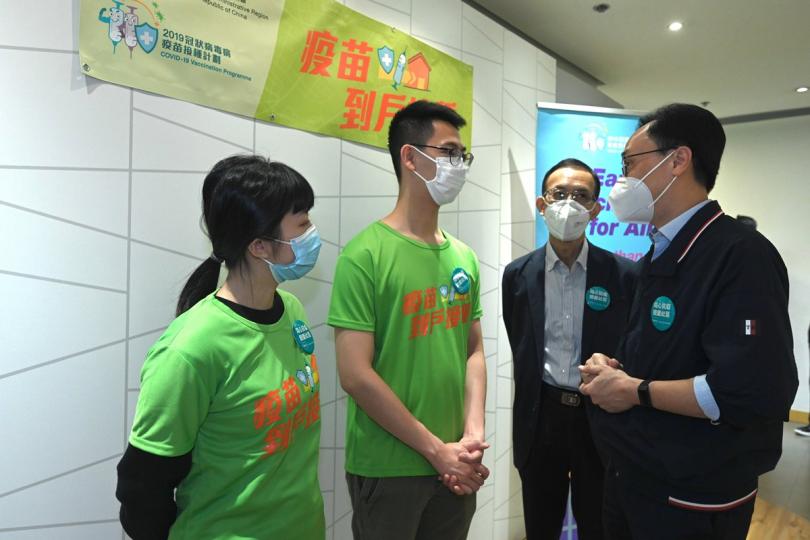 同心抗疫:  聶德權（右一）與疫苗到戶接種服務工作人員交談，了解他們的工作。