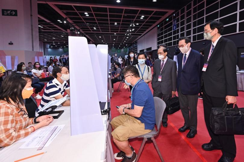 熟習流程:  馮驊（右二）巡視設於會議展覽中心的行政長官選舉主投票站，視察投票站工作人員在發票櫃枱模擬發出選票。