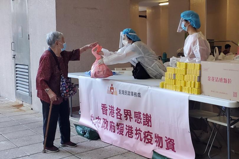 同心抗疫:  工作人員在荃灣受限區域向受限人士派發由中央人民政府捐贈的抗疫中成藥。   