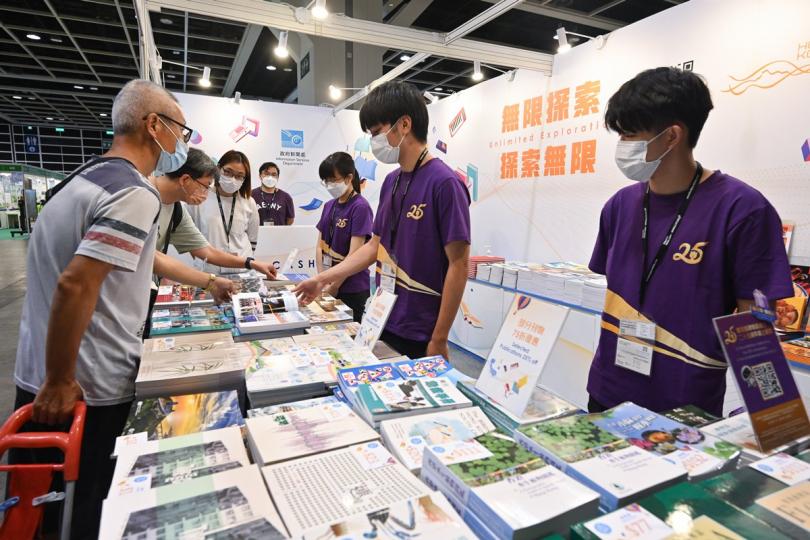 刊物展銷:  市民在新聞處的書展攤位閱覽政府刊物。