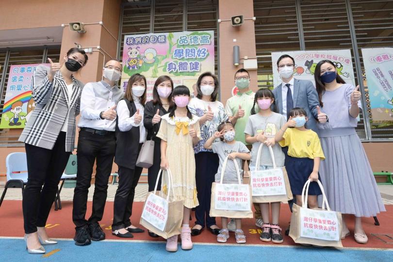 護己護人: 楊何蓓茵(後排右四)出席在聖公會聖雅各小學舉行的灣仔區學童疫苗接種日,鼓勵學童和家長一起接種新冠疫苗。 護己護人: 楊何蓓茵(後排右四)出席在聖公會聖雅各小學舉行的灣仔區學童疫苗接種日,鼓勵學童和家長一起接種新冠疫苗。