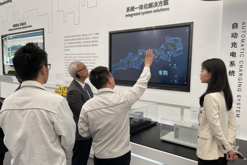 環保先鋒:  謝展寰（右三）參觀新能源車製造商比亞迪總部展覽廳，聽取工作人員介紹新能源車的最新發展。