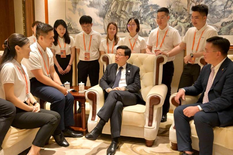 分享得益:  李家超（前排中）在海南出席港澳青年志願者證書頒發儀式，與擔任志願者的青年交流。