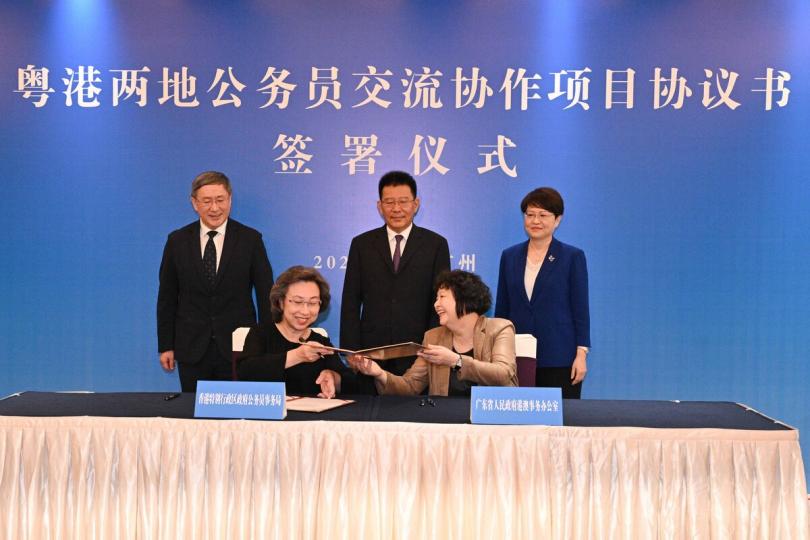 加強溝通:  在王靈桂（中）、卓永興（左一）和馮玲（右一）見證下，楊何蓓茵（左二）和李煥春簽署並交換協議書。