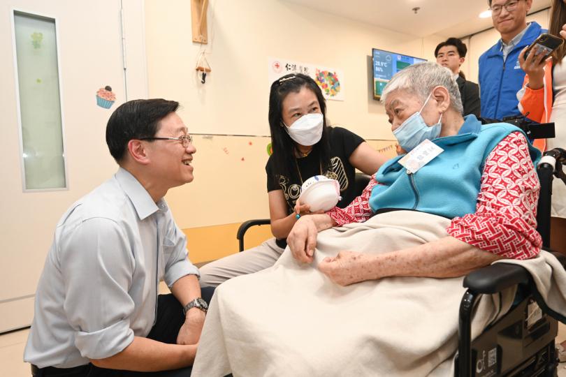 關愛共融:  李家超（左）在仁濟醫院嚴徐玉珊卓智中心與長者及其家庭照顧者交談。