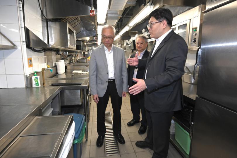 先行先試:  謝展寰（左）視察連鎖快餐店廚房處理垃圾的過程，聽取餐廳負責人對準備先行先試各項安排和需要。