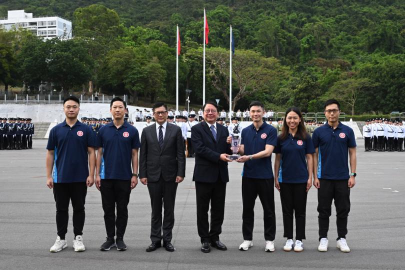 團結一致:  升旗儀式後，陳國基（中）和鄧炳強（左三）頒發維護國家安全盃獎盃。