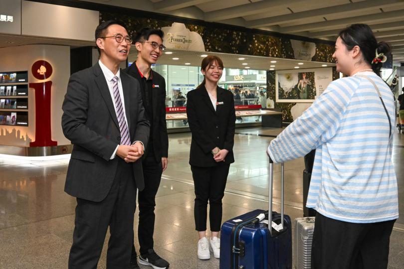 好客之道:  楊潤雄（左一）歡迎來自內地的個人遊旅客，並與他們交談。
